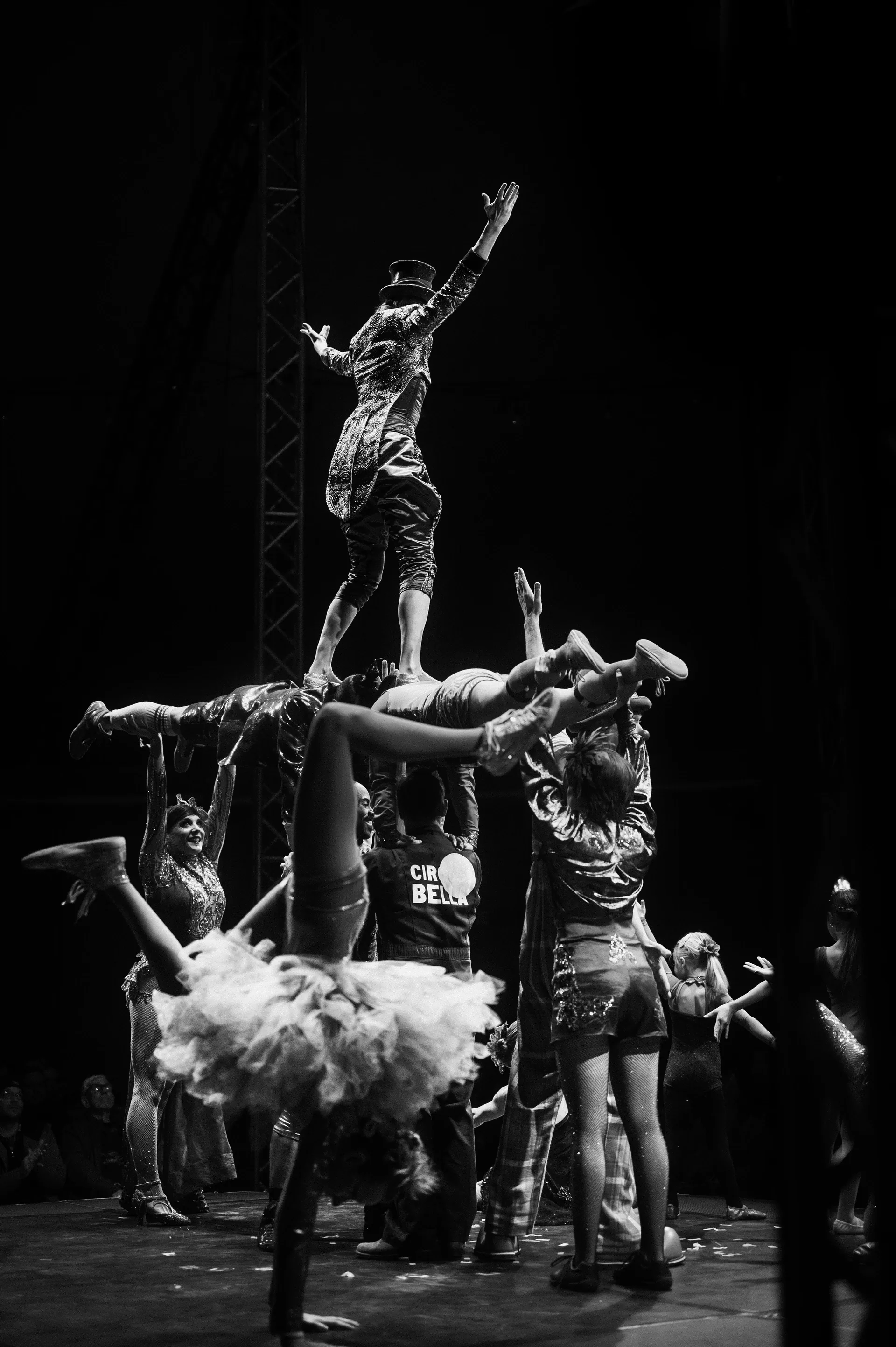 Ensemble forms a multi-person acrobatic balance onstage.