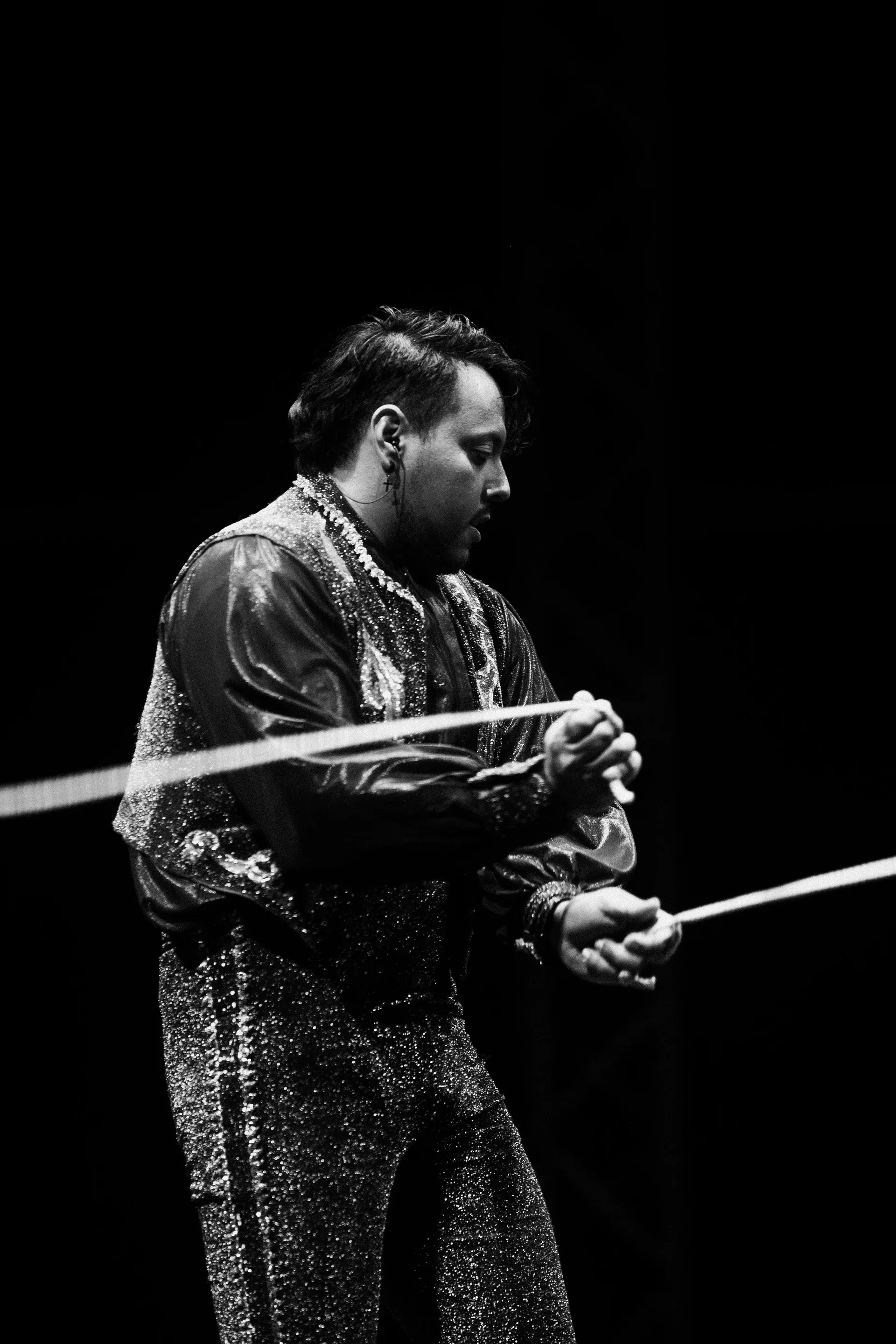 Performer pulls a long white ribbon taut across the stage.