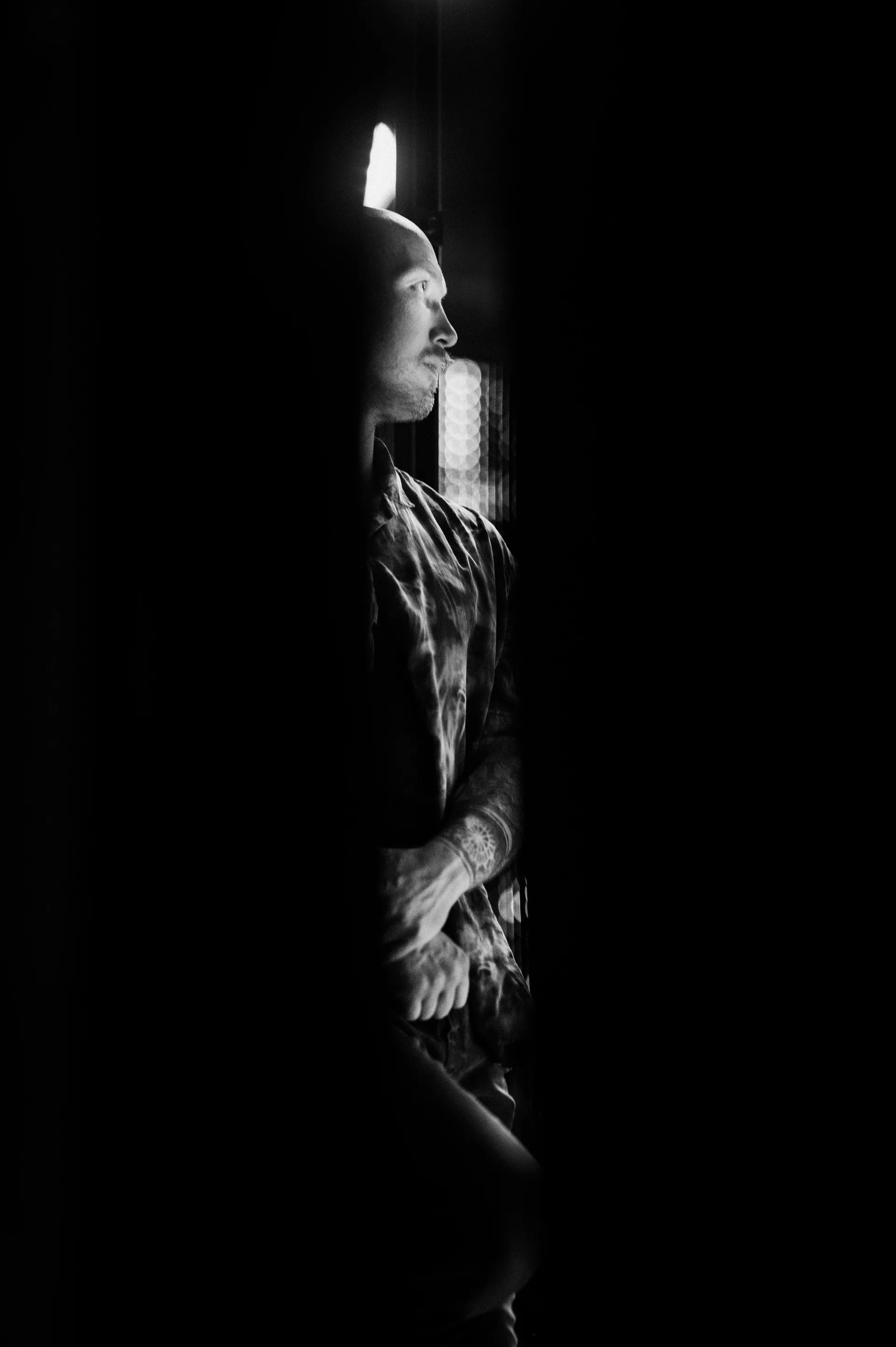 Performer is partly concealed behind a narrow opening in the stage curtain.