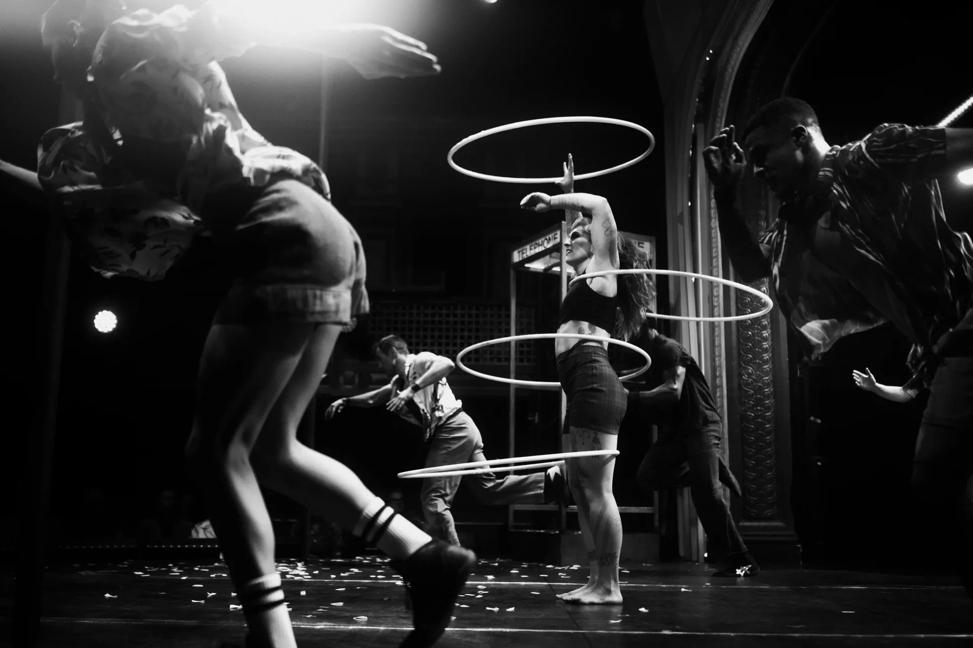 Several performers manipulate hoops while others move around them.