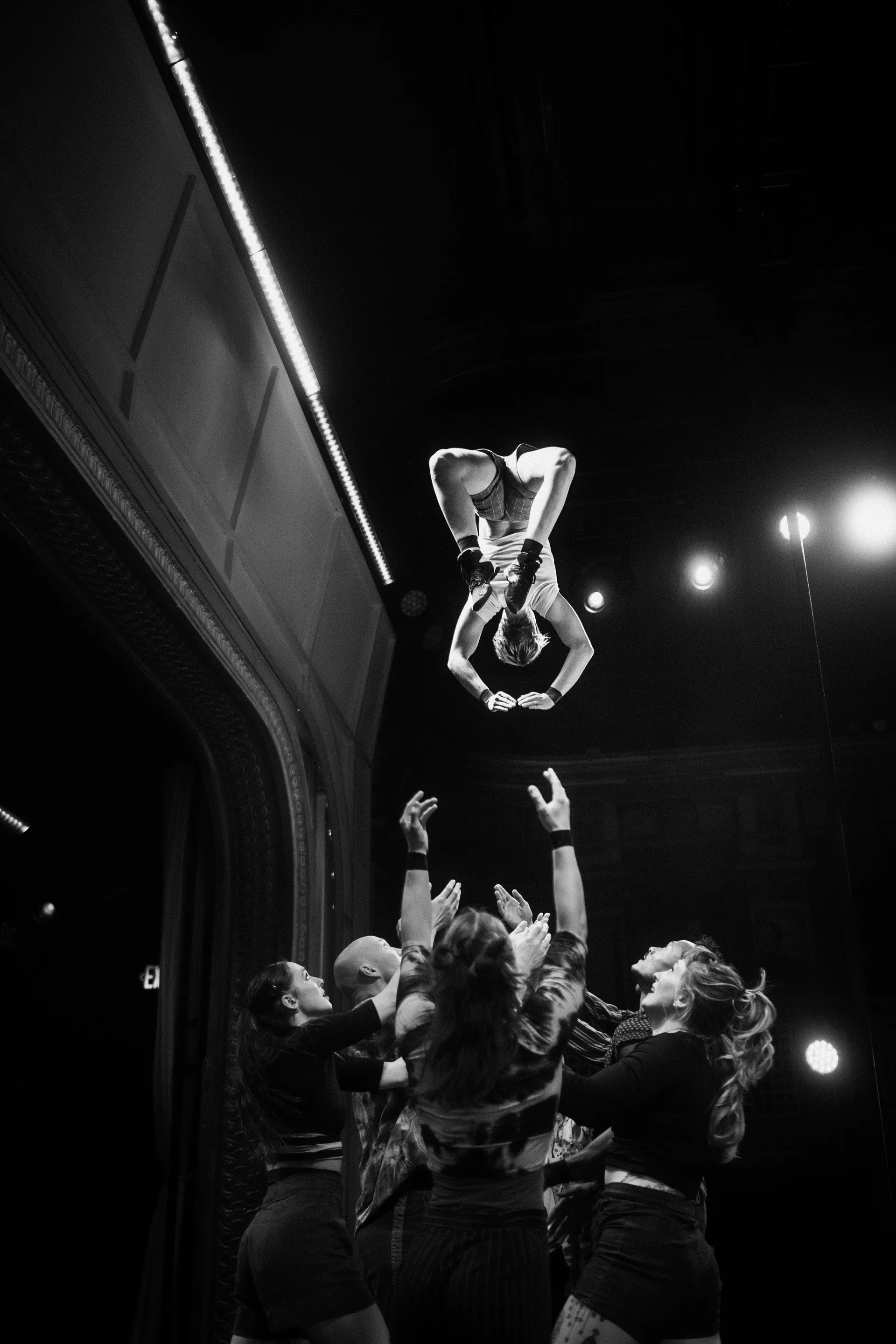 Acrobat is tossed into the air above a group of performers.