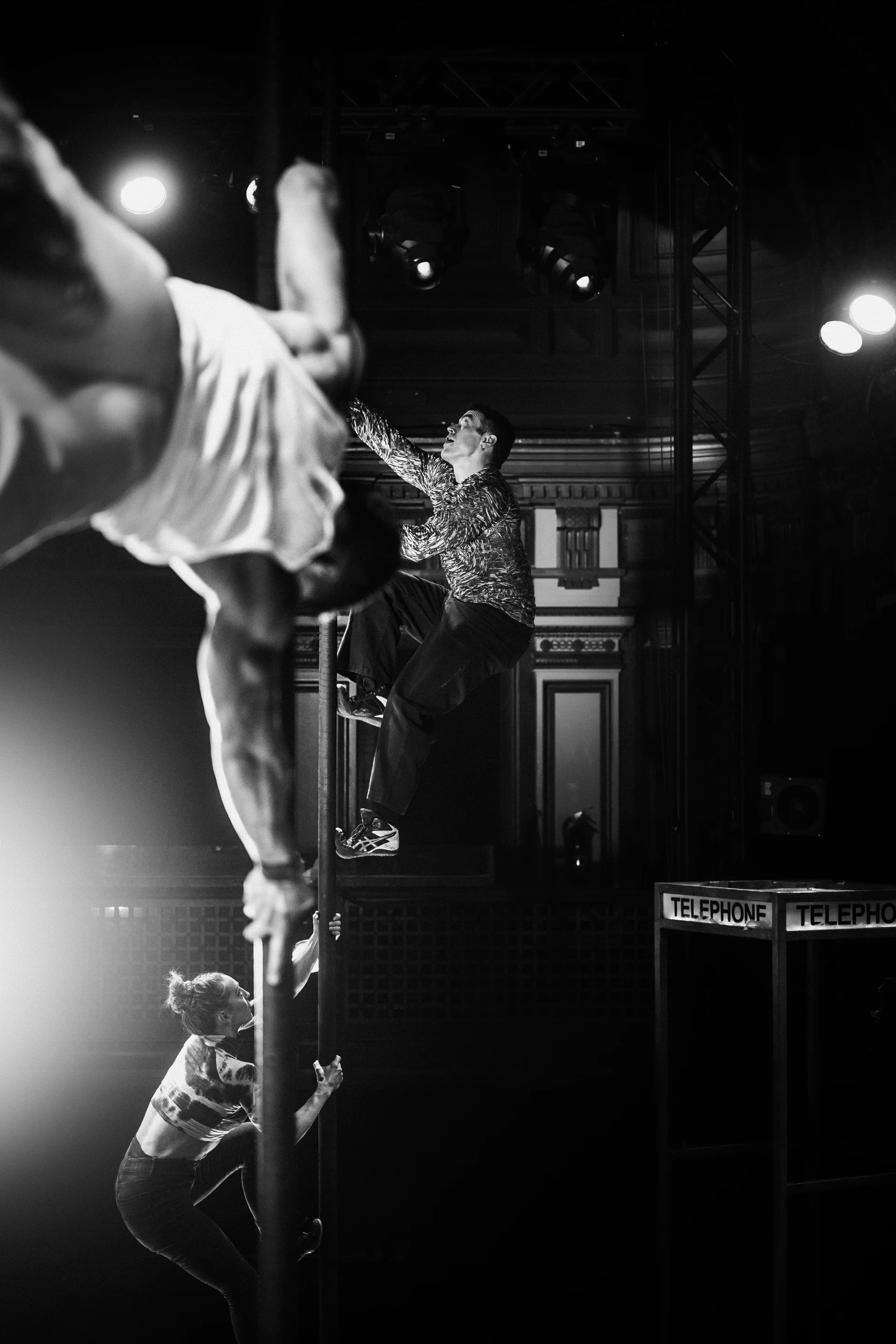 Acrobat extends horizontally while supported by a partner's raised feet.