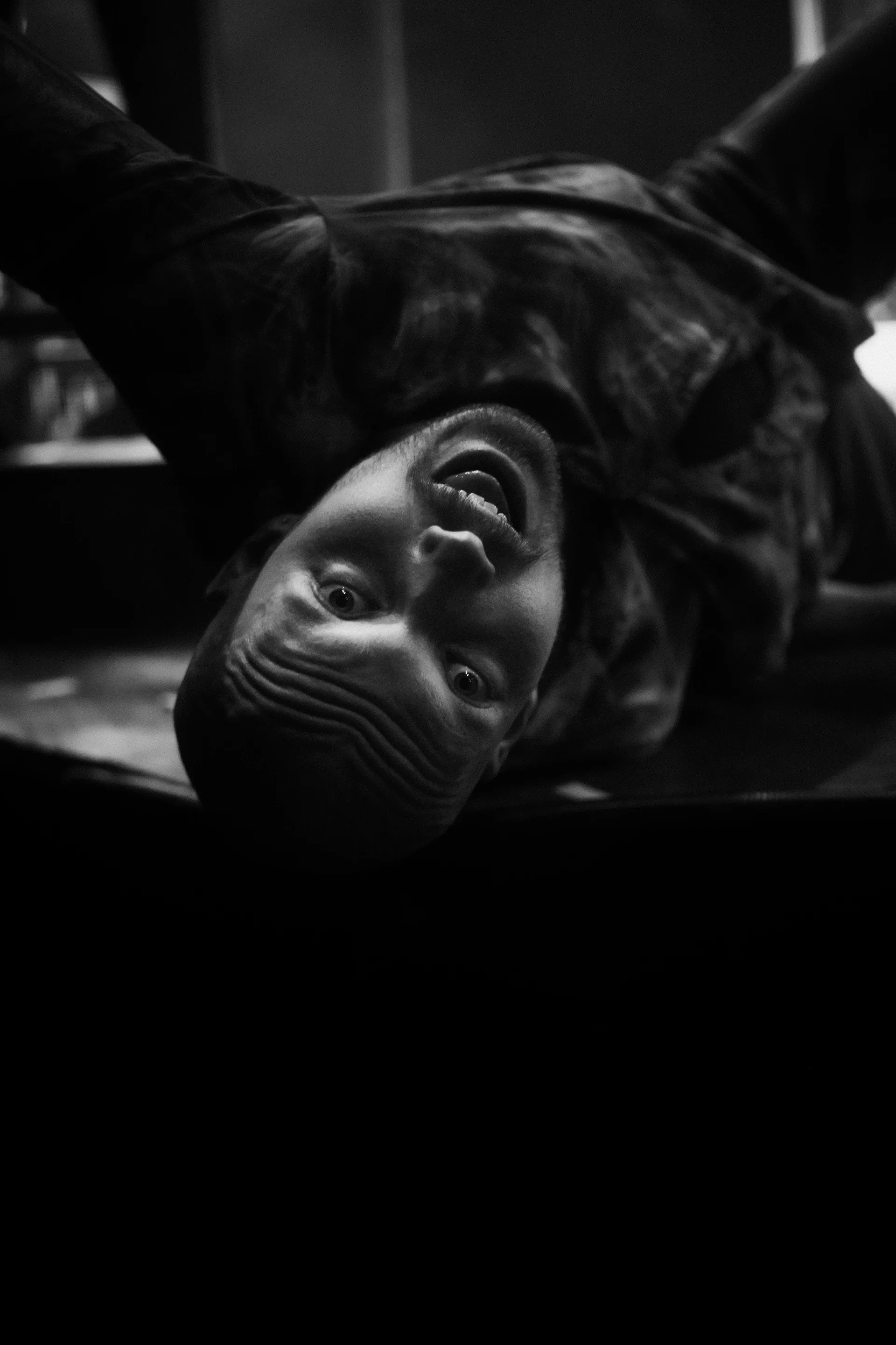 Close view of a performer lying on the stage with the face turned toward the audience.