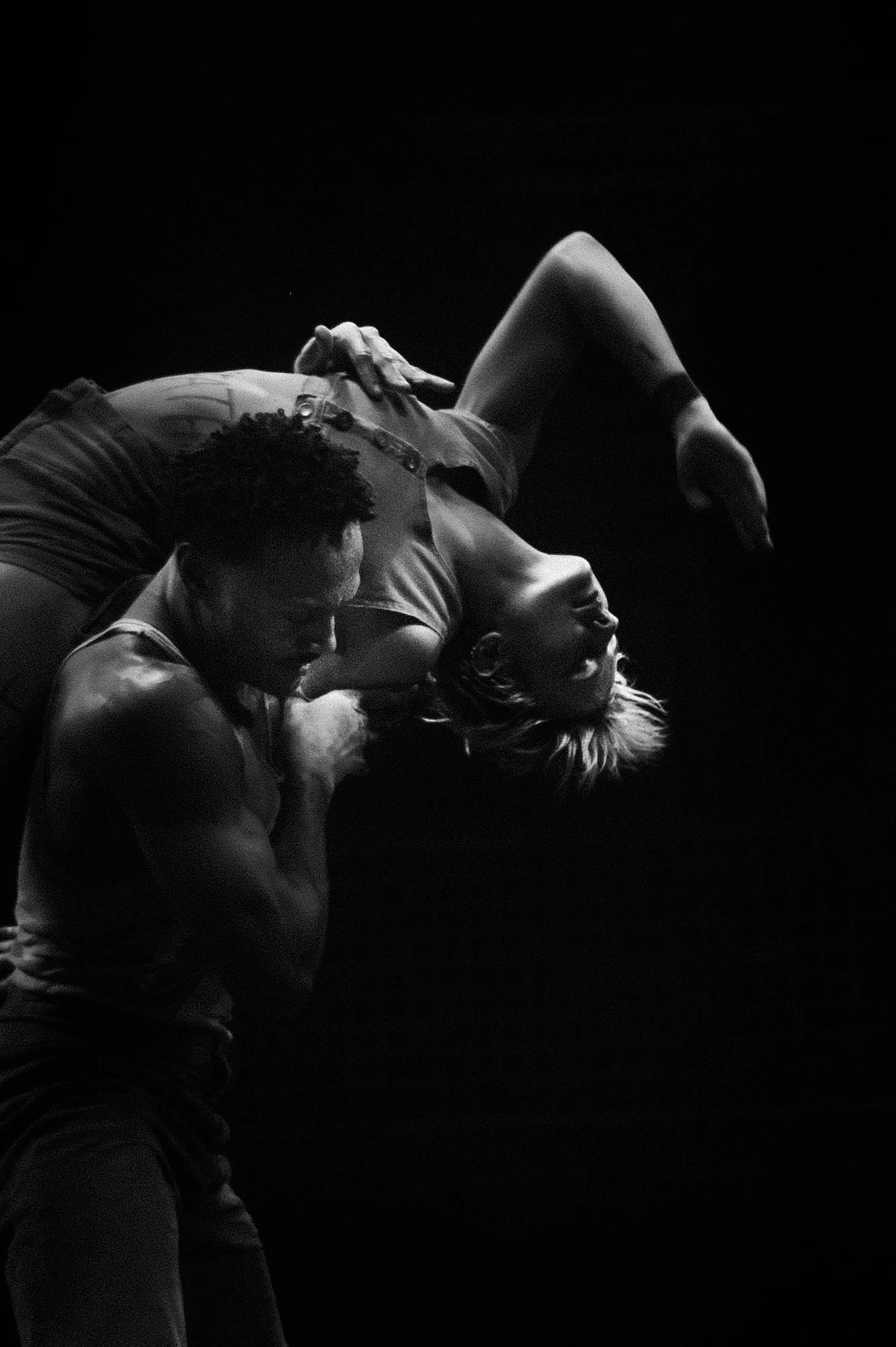 One performer carries another curled across the shoulders.
