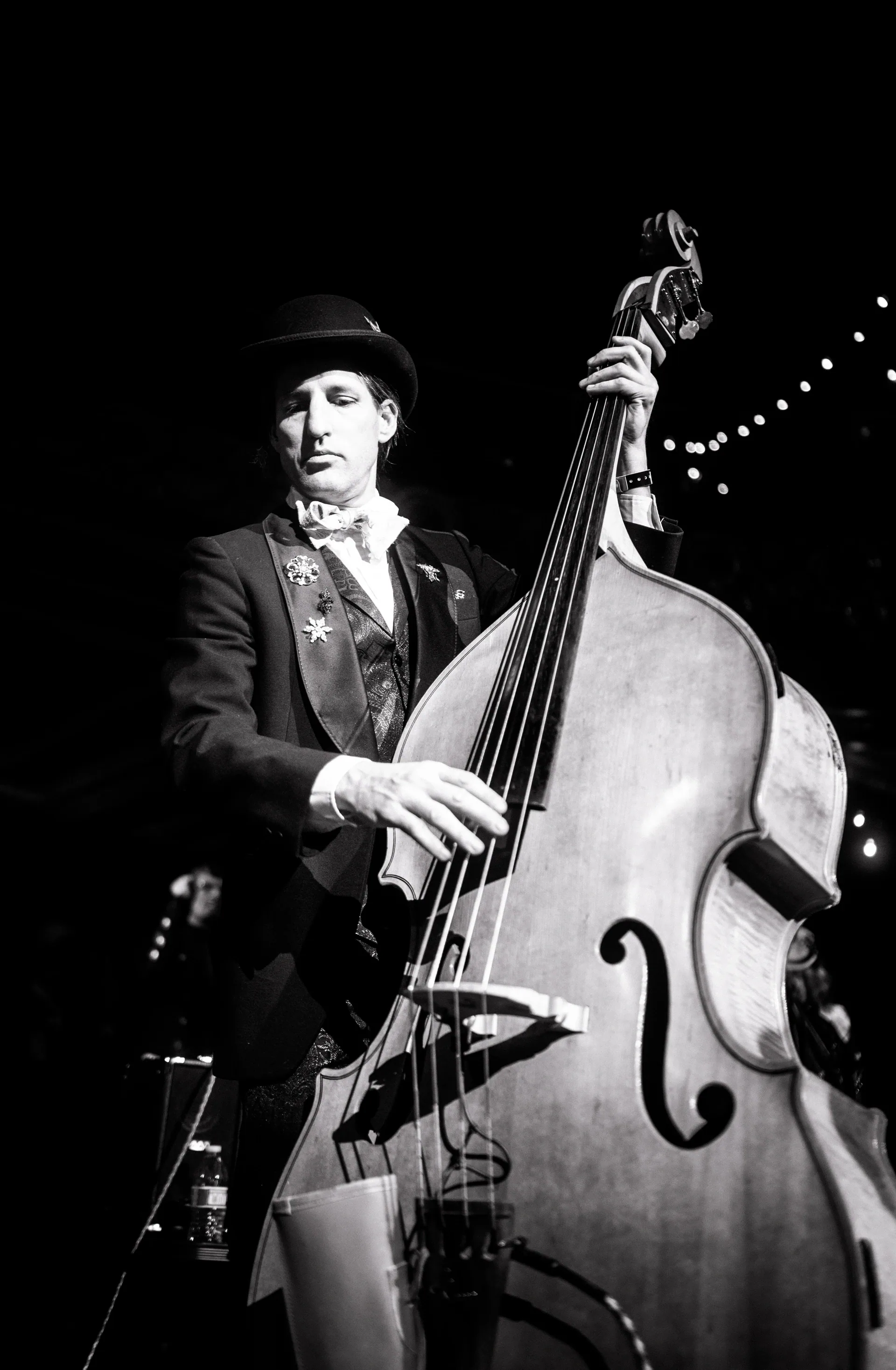 Musician in a hat plays an upright bass.