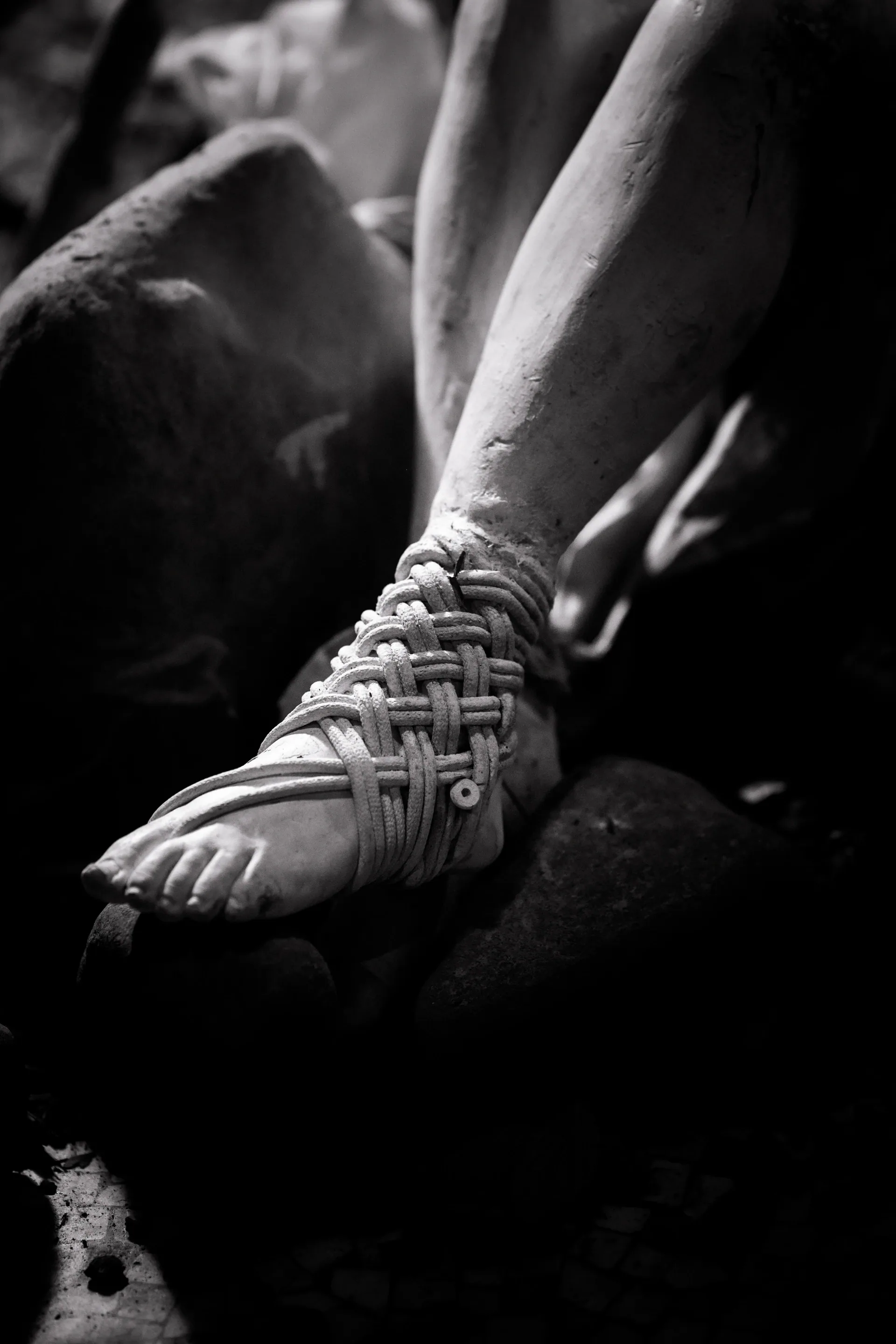 Close view of a laced shoe resting on another person's leg.