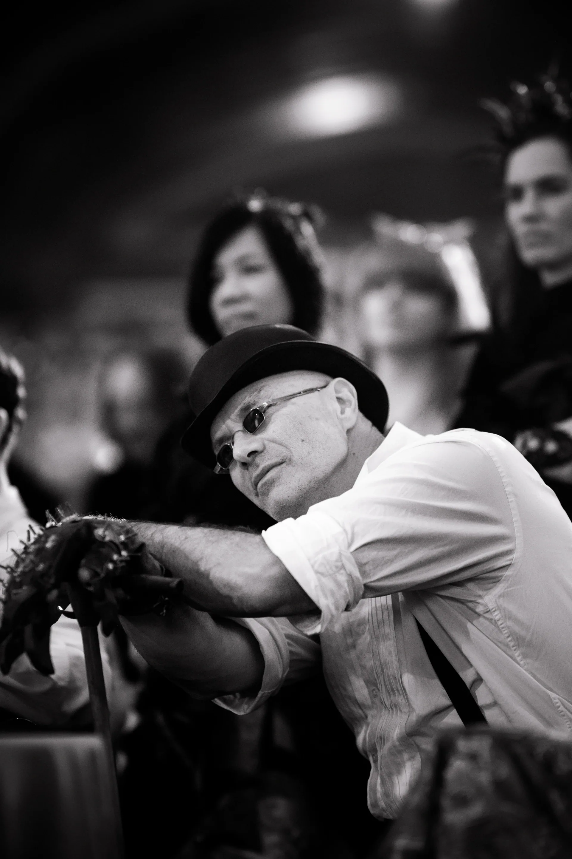 Person in a cap and glasses extends gloved hands while watching the performance.