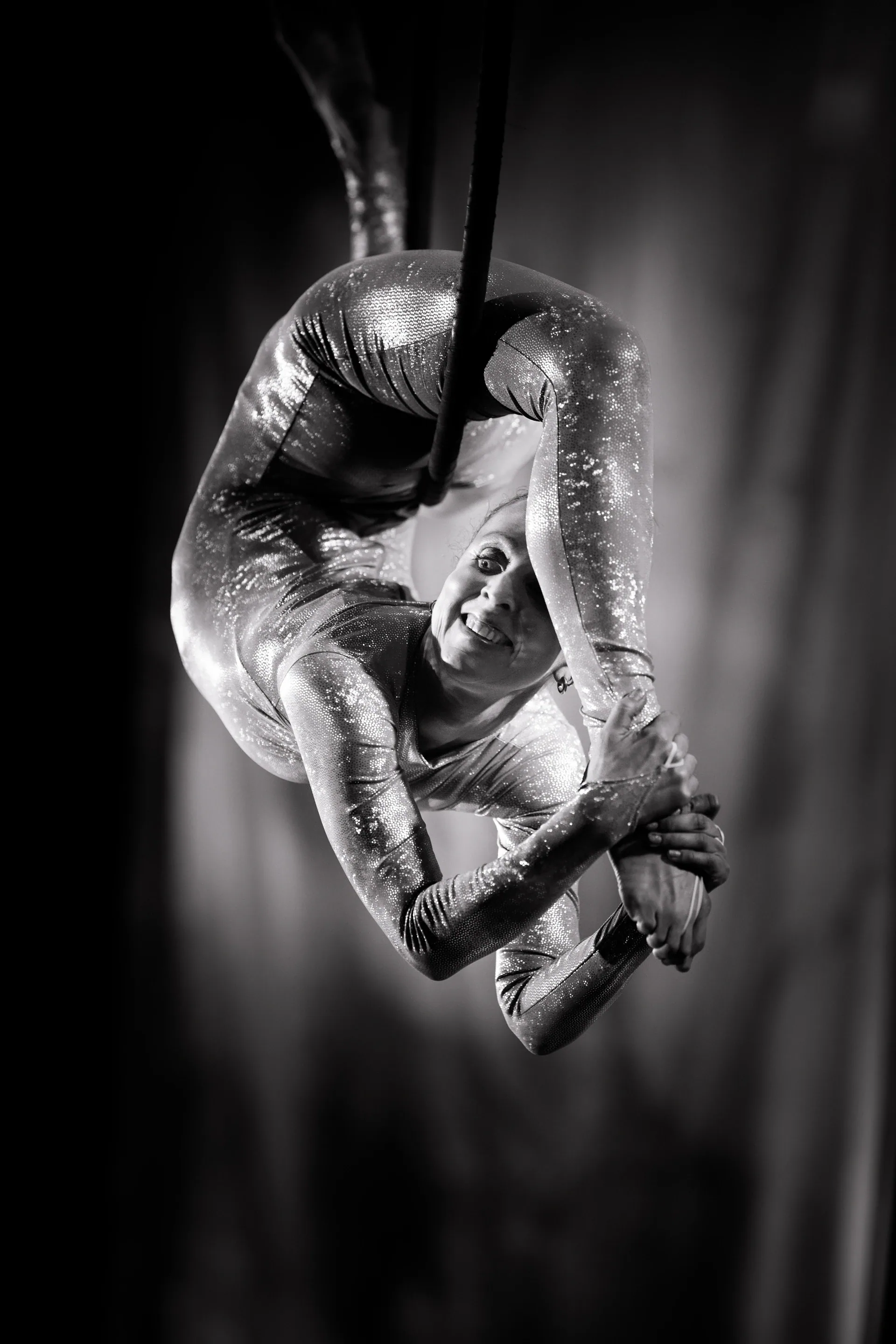 Aerialist curls tightly within a suspended hoop.