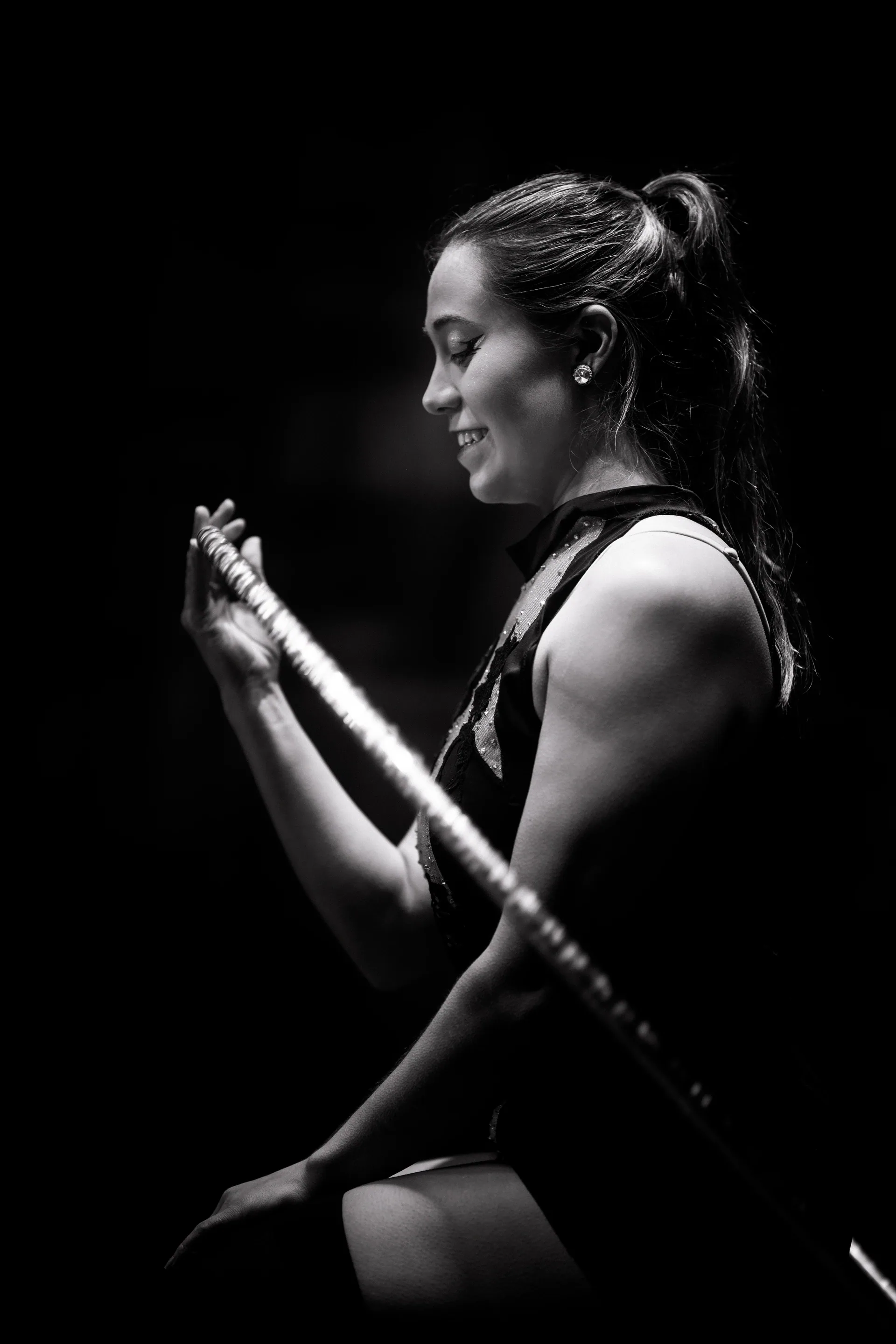Kneeling performer handles a long rope across the stage.