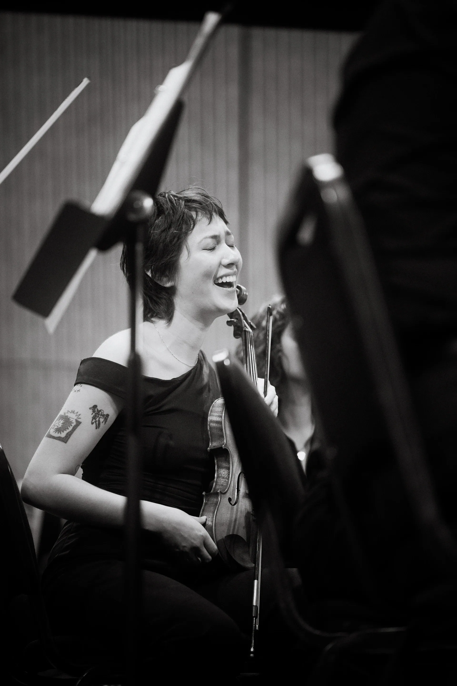 Musician smiles while seated with a cello and bow.