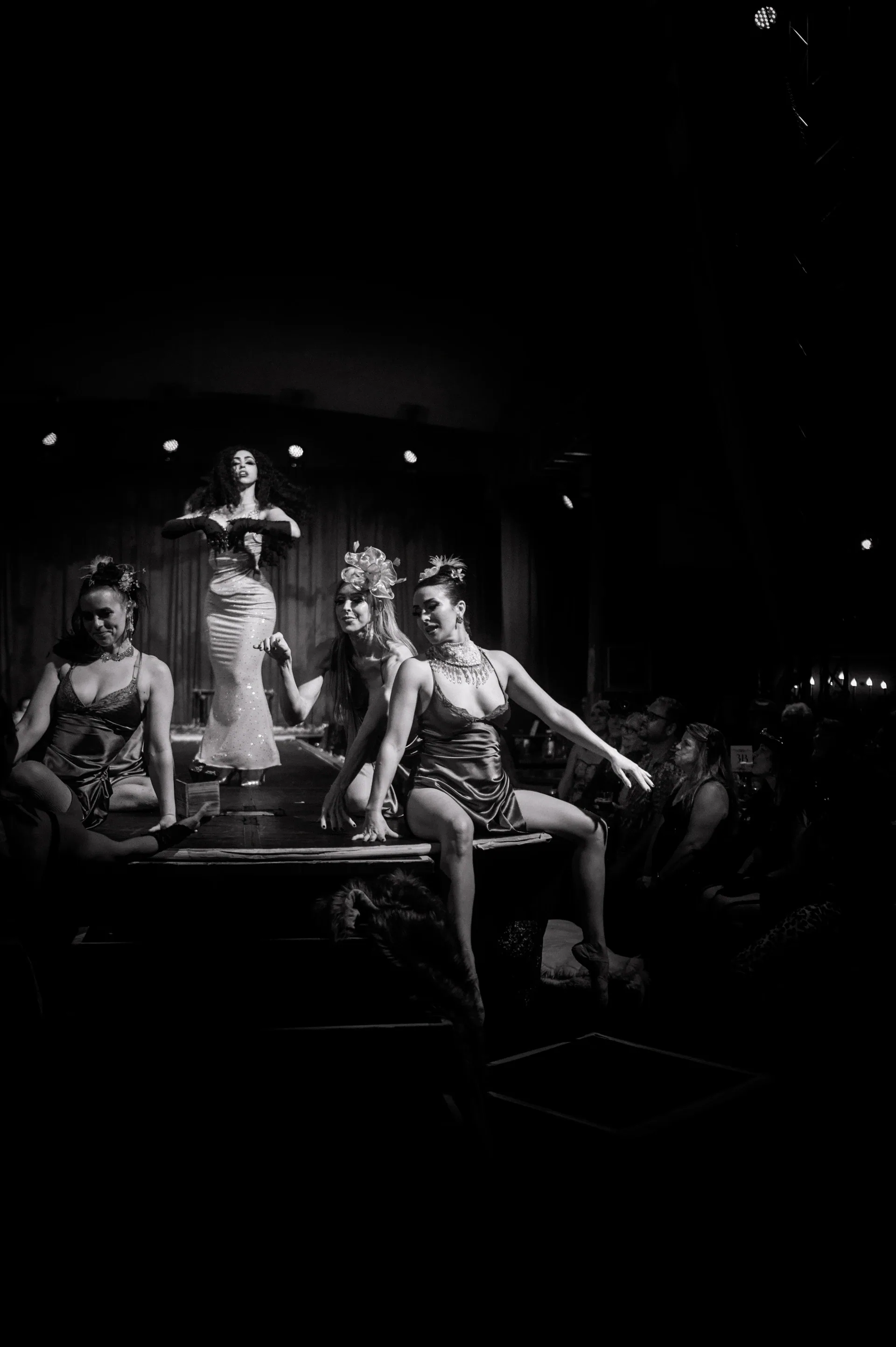 Several costumed performers sit together around a table.