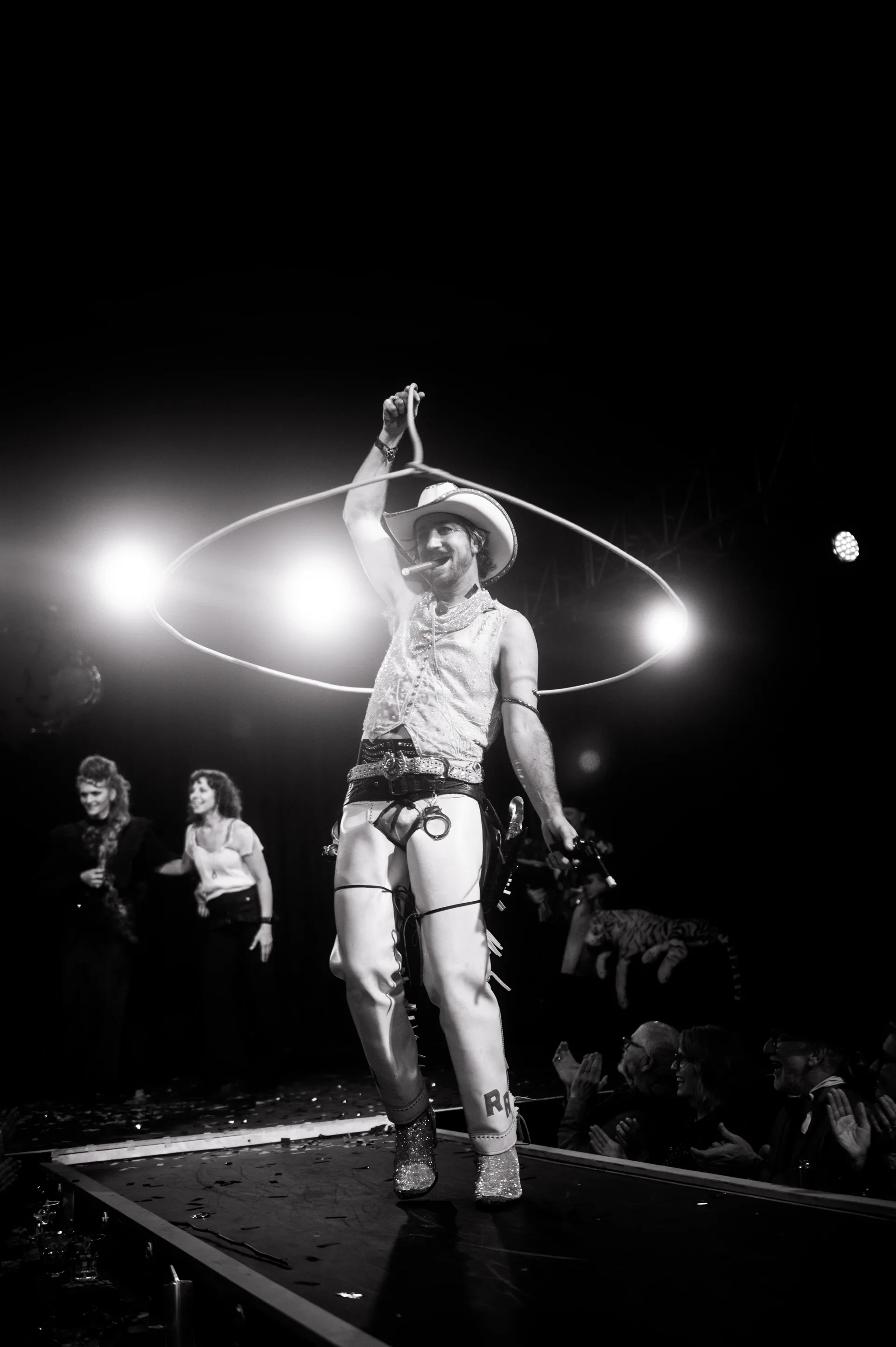 Performer spins a hoop around the body on a narrow stage.