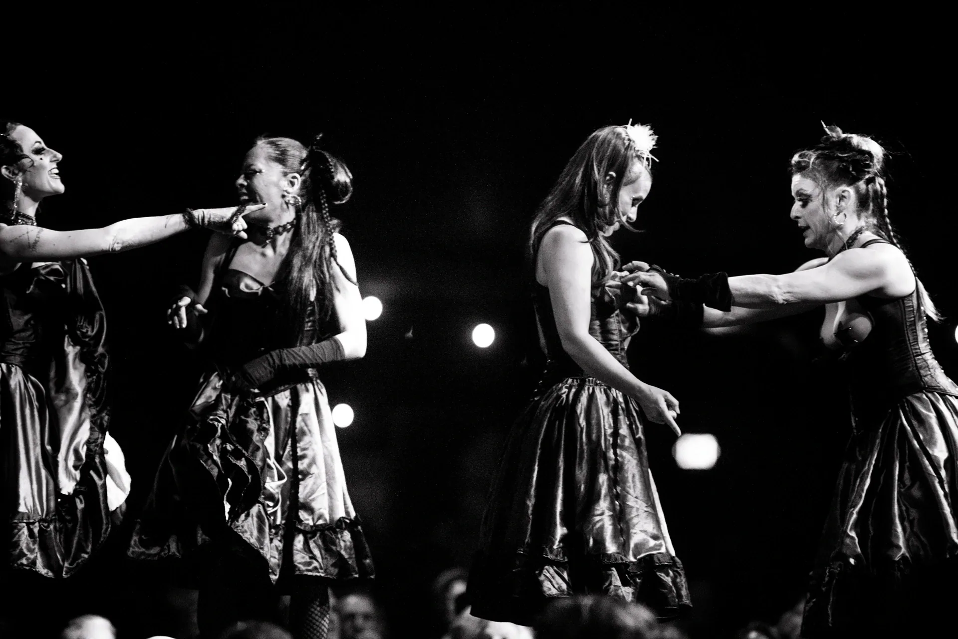 One performer points toward another in a group onstage.
