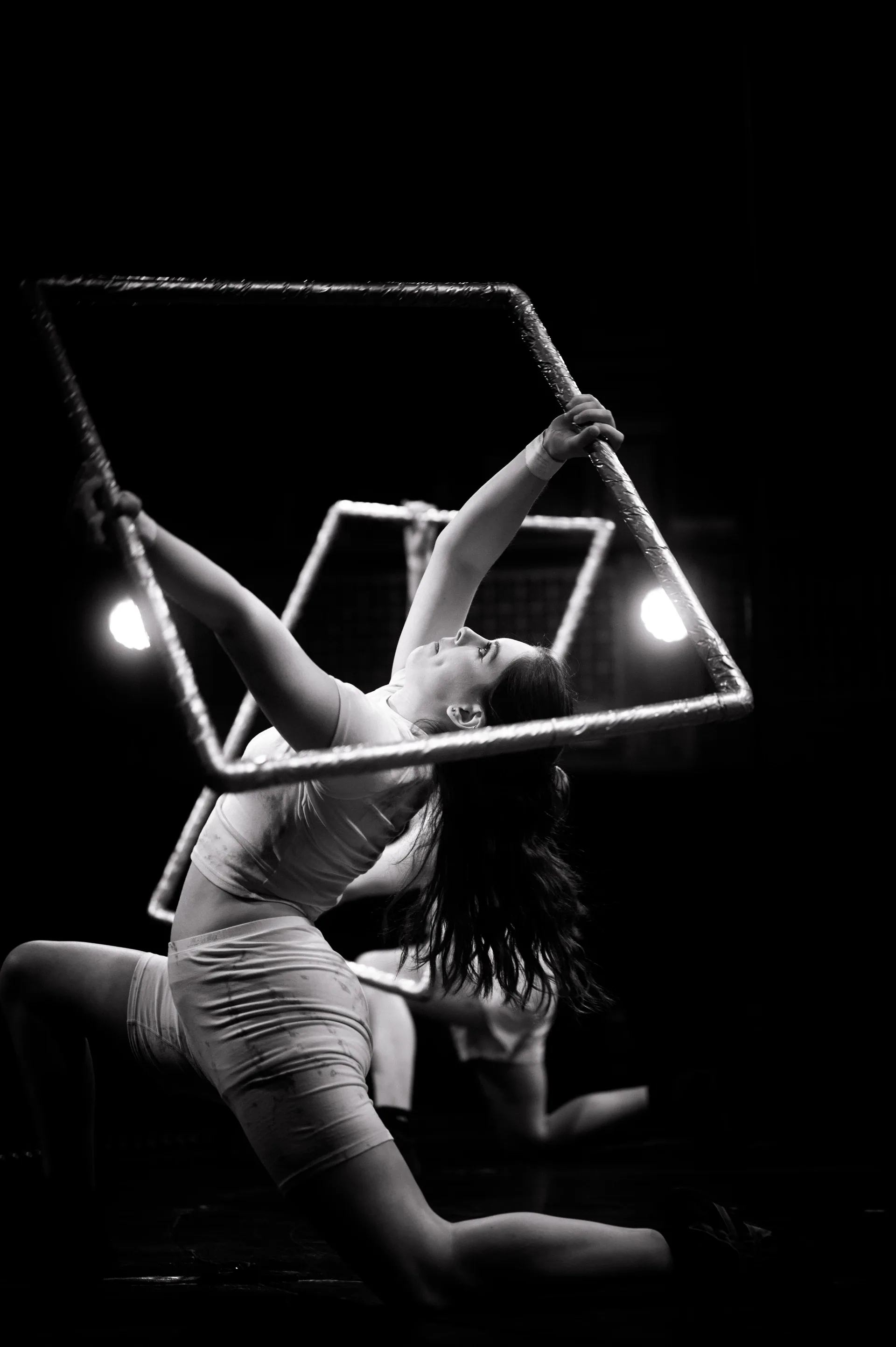 Dancer poses inside two angular rectangular frames.