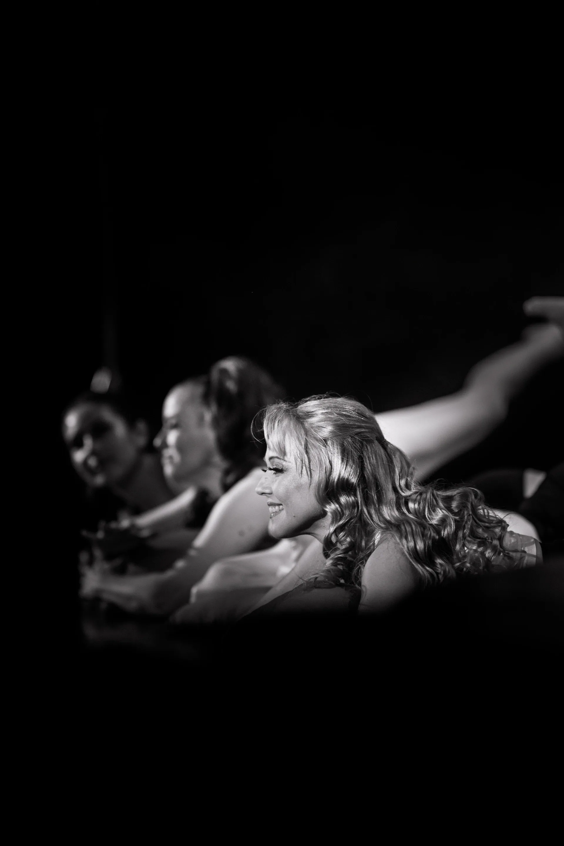 Several people lie at the edge of the stage watching the performance.